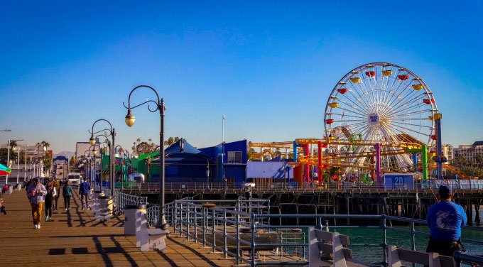 colorful rides and lamp posts on wooden pier