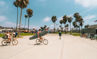 sidewalk filled with cyclists and surfers