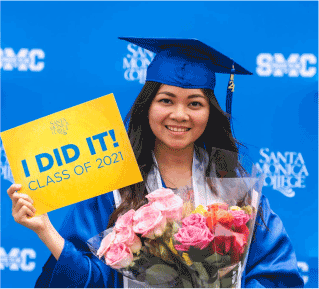 smiling female graduate holding flowers